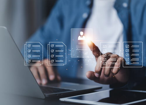 Person arbeitet am Laptop und interagiert mit einer digitalen Benutzeroberfläche mit Checklisten und Profilsymbolen, die Online-Formulare und Datenverwaltung visualisiert